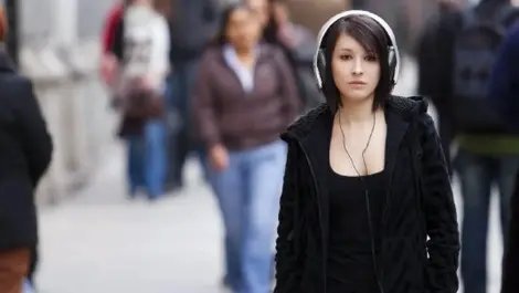Pedestrians wearing headphones campaign target